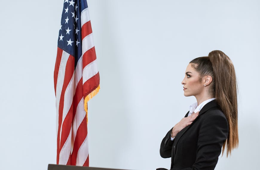 Woman in Black Blazer Standing Beside the US Flag
