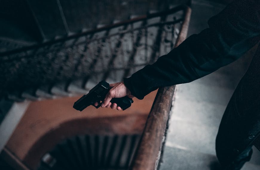 Person in Black Jacket Holding Black Gun
