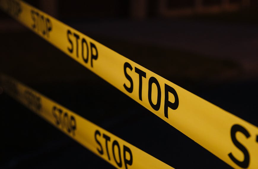 Yellow stop tape in a night crime scene setup, creating a tense atmosphere.