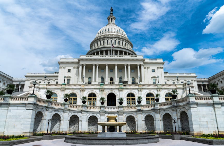 Exterior view of the iconic US Capitol Building on a sunny day in Washington, DC.