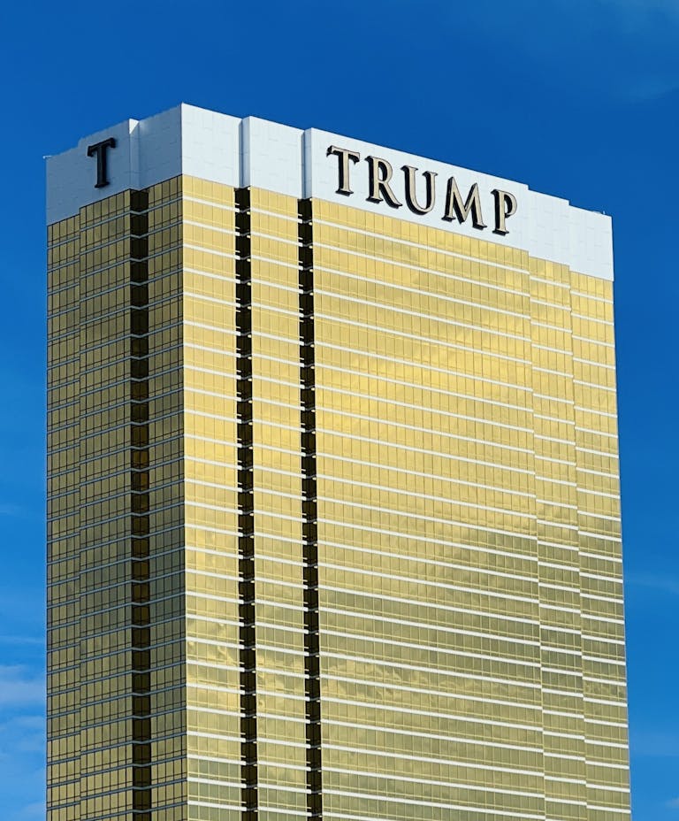 A striking view of Trump Tower in Las Vegas with its golden facade against a blue sky.