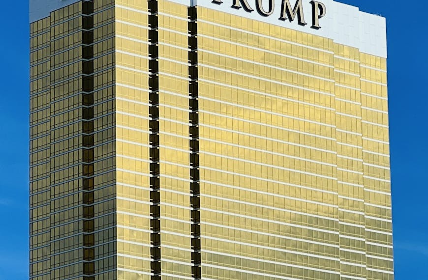 A striking view of Trump Tower in Las Vegas with its golden facade against a blue sky.